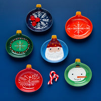 Set of colorful Christmas-themed plates on a blue background