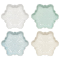 Four star-shaped ceramic dishes in white, light blue, and beige on a white background
